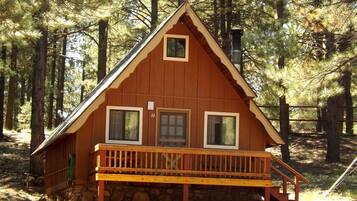 Une cabane en bois dotée d’un balcon, de fondations en pierre et du numéro « 10 » sur la porte.