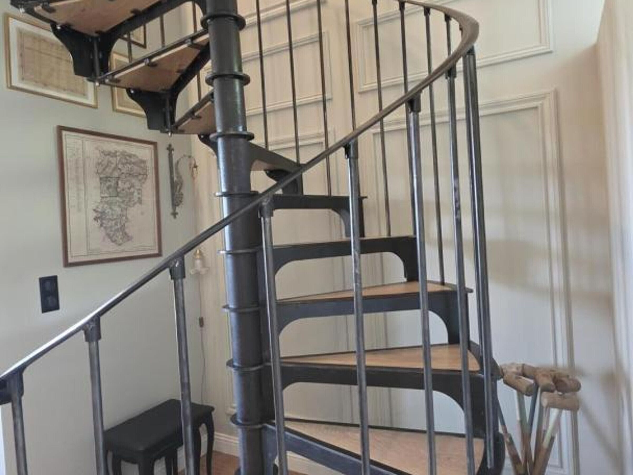 Una scala a chiocciola con ringhiere in metallo e gradini in legno.