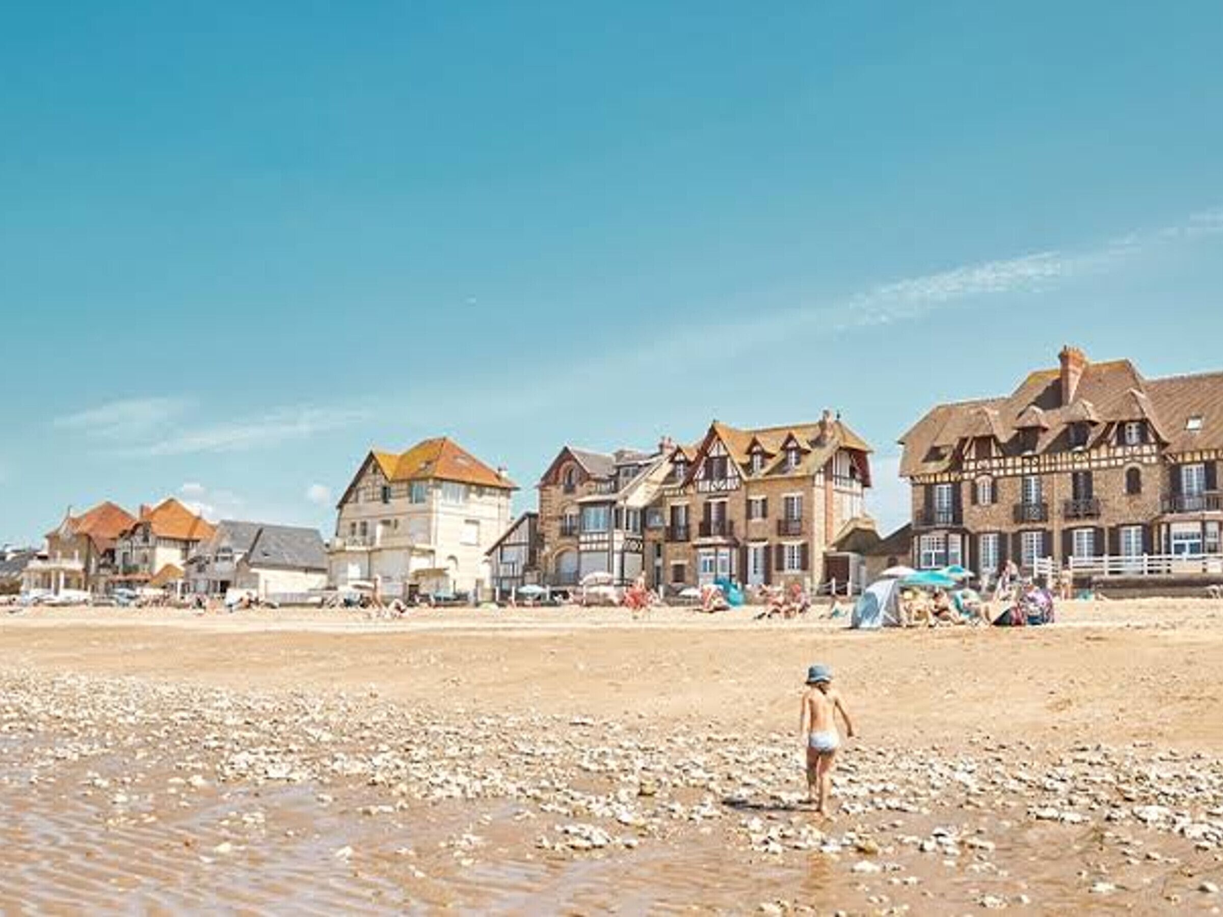 Ein Strand mit Gebäuden im Hintergrund.
