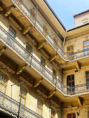 Un edificio de varios pisos con balcones decorativos y detalles arquitectónicos clásicos.