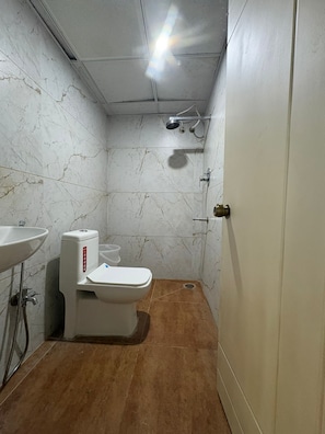 A bathroom with a toilet, sink, and shower. - Hotel Raasaa Grand Rooms (Bengaluru)