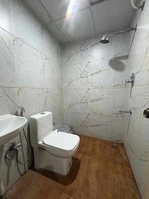 A bathroom with a toilet, sink, and shower. - Hotel Raasaa Grand Rooms (Bengaluru)