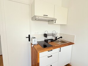A compact kitchenette with a countertop, a toaster, a sink, and a range hood. - Renovated studio in quiet area - 2 guests (Villers-sur-Mer)