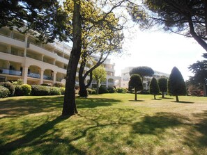 A multi-story building with a courtyard, surrounded by trees and well-maintained grass. - Apartment with balcony - 3 guests in La Baule (La Baule)