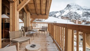 A wooden deck with seating, a view of snow-covered mountains, and a wooden building structure. - Spacious chalet near slopes - 14 guests (Saint-Martin-de-Belleville)