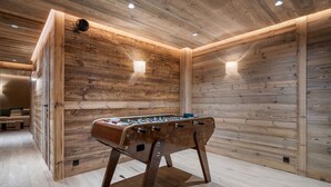 A wooden-floored room with a foosball table, wooden walls, and recessed lighting. - Spacious chalet near slopes - 14 guests (Saint-Martin-de-Belleville)