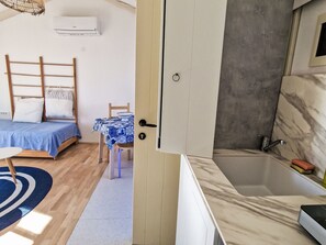 A bedroom with a bed, bedside table, and a small table with a chair. - Apartment Ivas with balcony - A2 by Interhome (Umag/Zambratija)