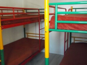 Ein Stockbett mit roten und grünen Geländern, einer gelben Stange und einem grauen Boden.