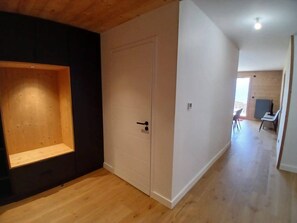 Ein Zimmer mit Holzboden, einer weißen Tür und einem kleinen Tisch mit Stühlen.