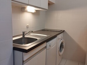 A compact kitchen with a stainless steel sink, a built-in dishwasher, and a washing machine. - Bright apartment, 6 guests, ski-in ski-out (Orcières Merlette)