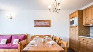 Ein Essbereich mit Holztisch, Stühlen und einer Kronleuchter.