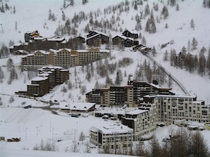 A snow-covered ski resort with multiple buildings, including lodges and a large hotel. - Cozy apartment, slopes view - 4 guests (Isola 2000)