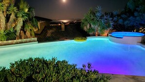 A nighttime swimming pool with a moon in the sky, surrounded by palm trees and a view of the ocean. - Villa with sea view, pets welcome - 12 guests (Bormes-les-Mimosas)