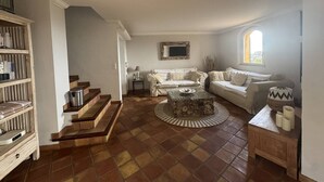 A living room with a fireplace, a sofa set, a coffee table, and a staircase. - Villa with sea view, pets welcome - 12 guests (Bormes-les-Mimosas)