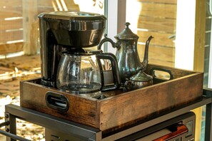 A coffee maker, a glass carafe, and a metal teapot on a wooden tray. - Unique Marshfront Treehouse Stay with Heated Soaking Tub & Adventure-Inspired Escape in Townsend, Georgia (Townsend)