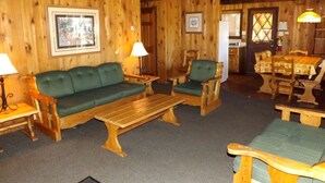 A wooden interior with a sofa, chairs, a table, and a dining set. - Spacious Cabin with Large Porch Ideal for Groups in Arizona (Flagstaff)