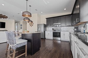 A modern kitchen with dark cabinets, stainless steel appliances, and a central island. - New Listing!  In Morgantown w/ Pools, Tennis/Pickleball (Gulf Shores)