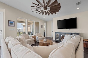 A spacious living room with a large sofa, two armchairs, a coffee table, and a TV mounted on the wall. - New Listing!  In Morgantown w/ Pools, Tennis/Pickleball (Gulf Shores)