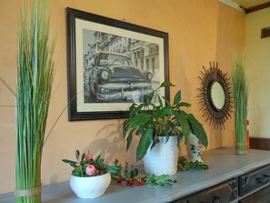 A framed vintage car photo, a white vase with green foliage, and a mirror on a wall. - Farmhouse Vacation Rental for 15 People Near the Somme Bay (Friville-Escarbotin)