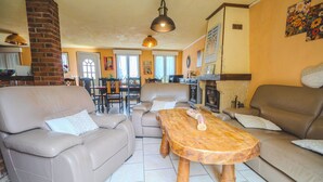 A living room with two sofas, a wooden coffee table, and a brick fireplace. - Farmhouse Vacation Rental for 15 People Near the Somme Bay (Friville-Escarbotin)