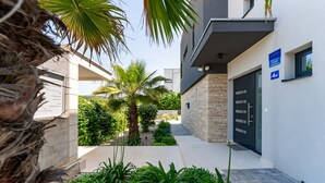 A modern building with a stone facade, a black door, and a blue sign indicating a 4A unit. - Villa Tamaris Zadarvillas (Bibinje)