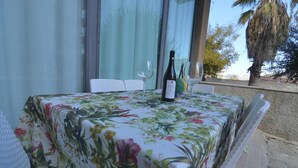 Een tafel met een tafelkleed met bloemen, een fles wijn en twee wijnglazen.