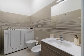 Ein modernes Badezimmer mit Toilette, Bidet und Waschbecken.