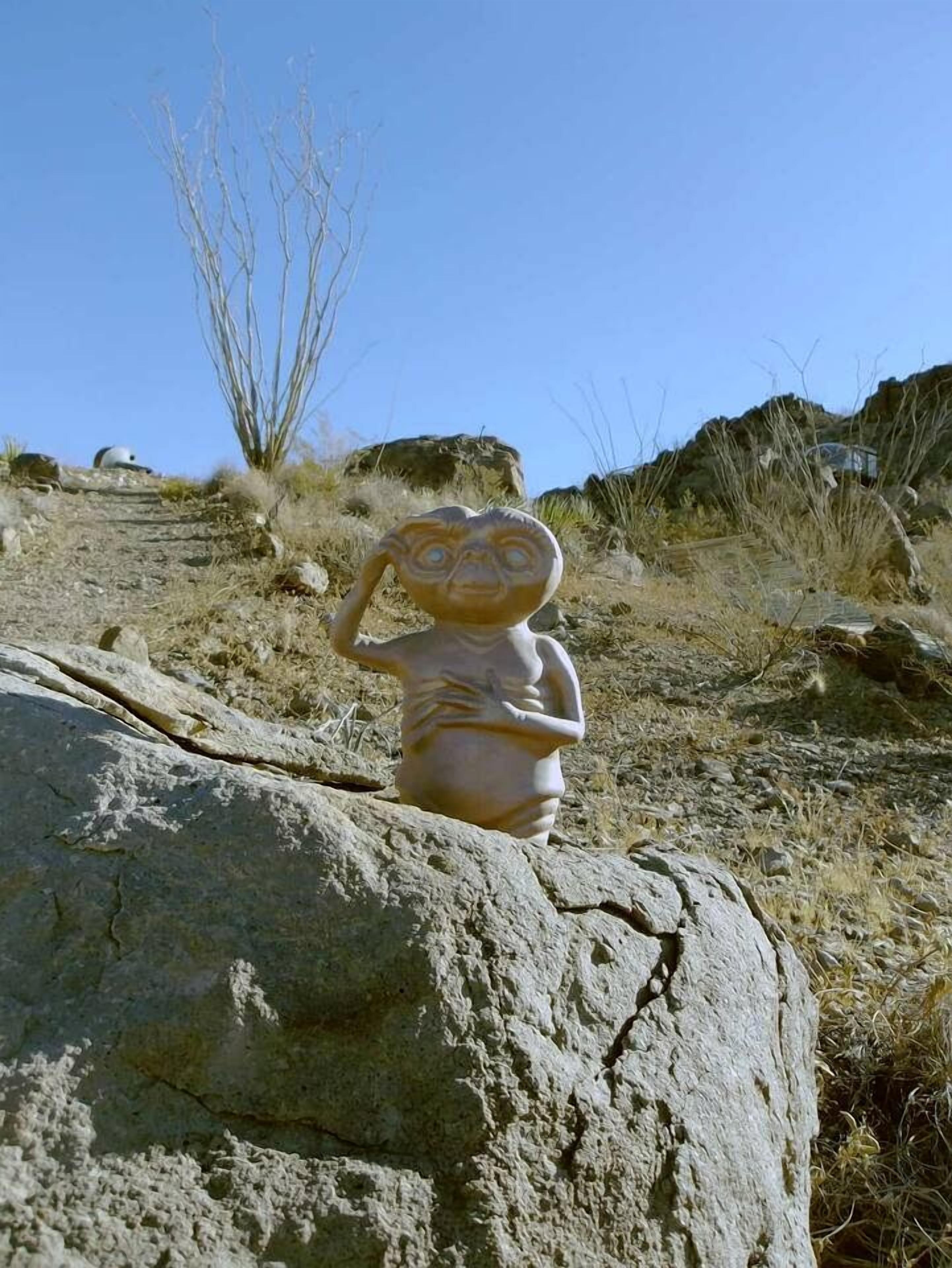 Une sculpture représentant une figure sur un rocher.