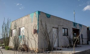 Un edificio con facciata in cemento, una porta e una finestra.