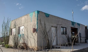A building with a concrete exterior, a door, and windows.