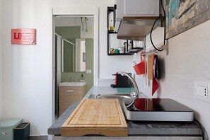 Une cuisine équipée d’une planche à découper en bois, d’un évier et d’une cuisinière.