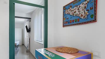 Ein Flur mit einem farbenfrohen Tisch mit der Aufschrift 'siciliano' und einer Karte von Sizilien an der Wand.