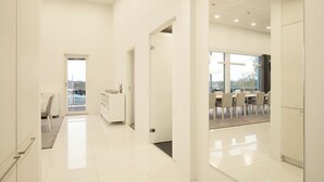 A modern hotel corridor with a dining area visible through a glass partition. - 2BR Villa with Panorama Views - Swing A (Naantali)
