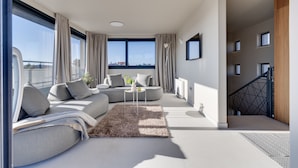 Ein modernes Wohnzimmer mit Sofa, Couchtisch und Blick auf die Stadt.