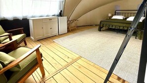 Ein Zelt mit Bett, einem kleinen Tisch und einem Stuhl.