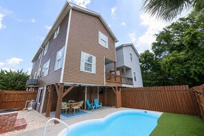 A two-story house with a backyard swimming pool, a wooden deck, and a fenced area. - Walk to the Beach 4 BR with a Private Pool! Cafe Mocha (Surfside Beach)