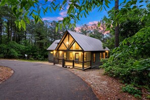 Eine Lodge mit großer Veranda, überdachter Terrasse und einem Metalldach.