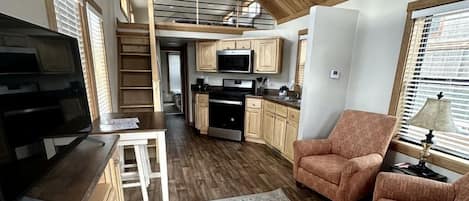 Un espacio habitable compacto con cocina, comedor y zona de estar.