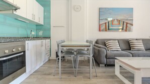 A modern kitchen with white cabinets, a stainless steel oven, and a teal backsplash. - Charming 1-bedroom Apartment With Ocean Views in Costa Adeje (Adeje)