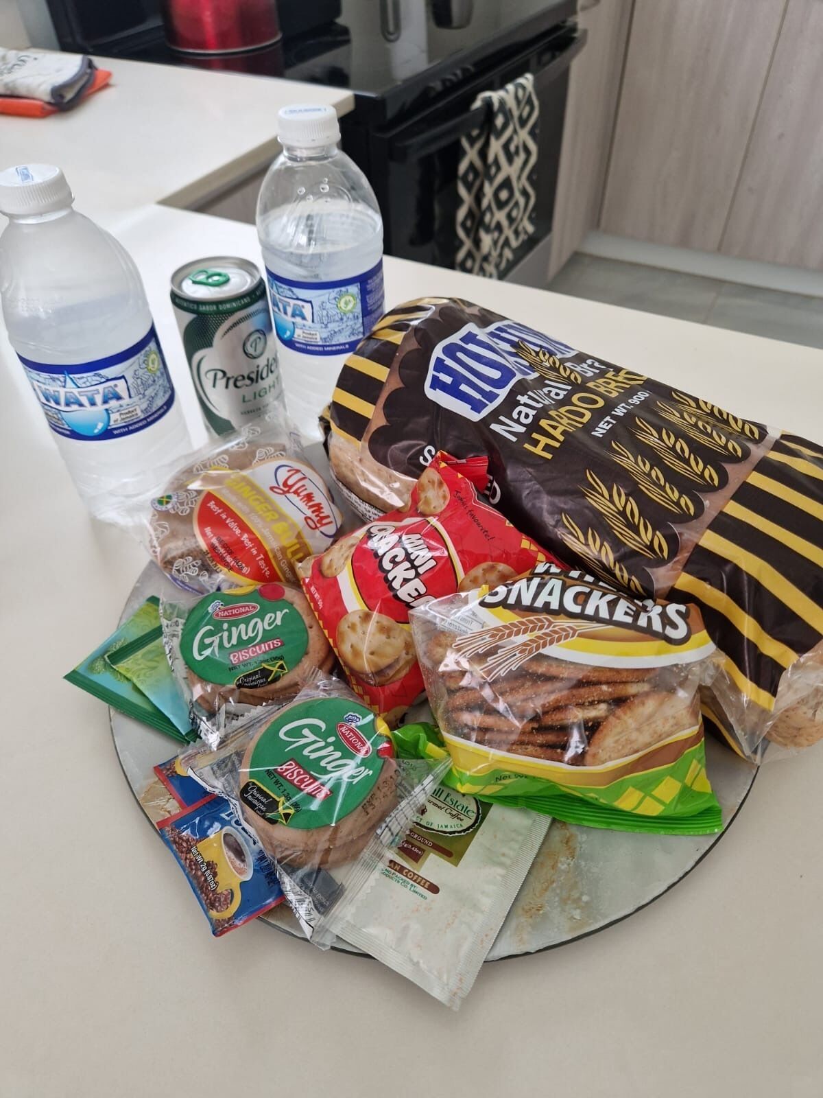 Diversos alimentos, incluindo lanches, biscoitos e bebidas, sobre uma bancada de cozinha.