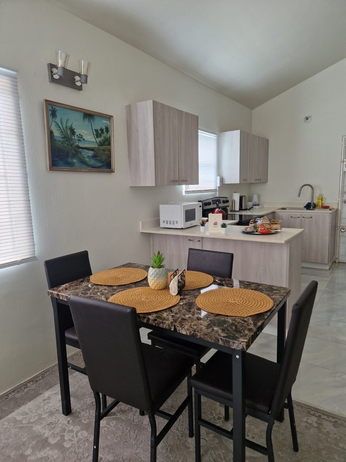A modern kitchen with wooden cabinets, a microwave, a stove, and a sink.
