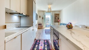 Uma cozinha moderna com bancadas de mármore, uma ilha central e vista para o exterior.