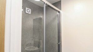 A glass-enclosed shower with a visible sink and a ventilation unit on the wall. - Walcott Lodges - Catley (Lincoln)