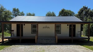 A single-story building with a metal roof, two visible doors, and a small porch area.