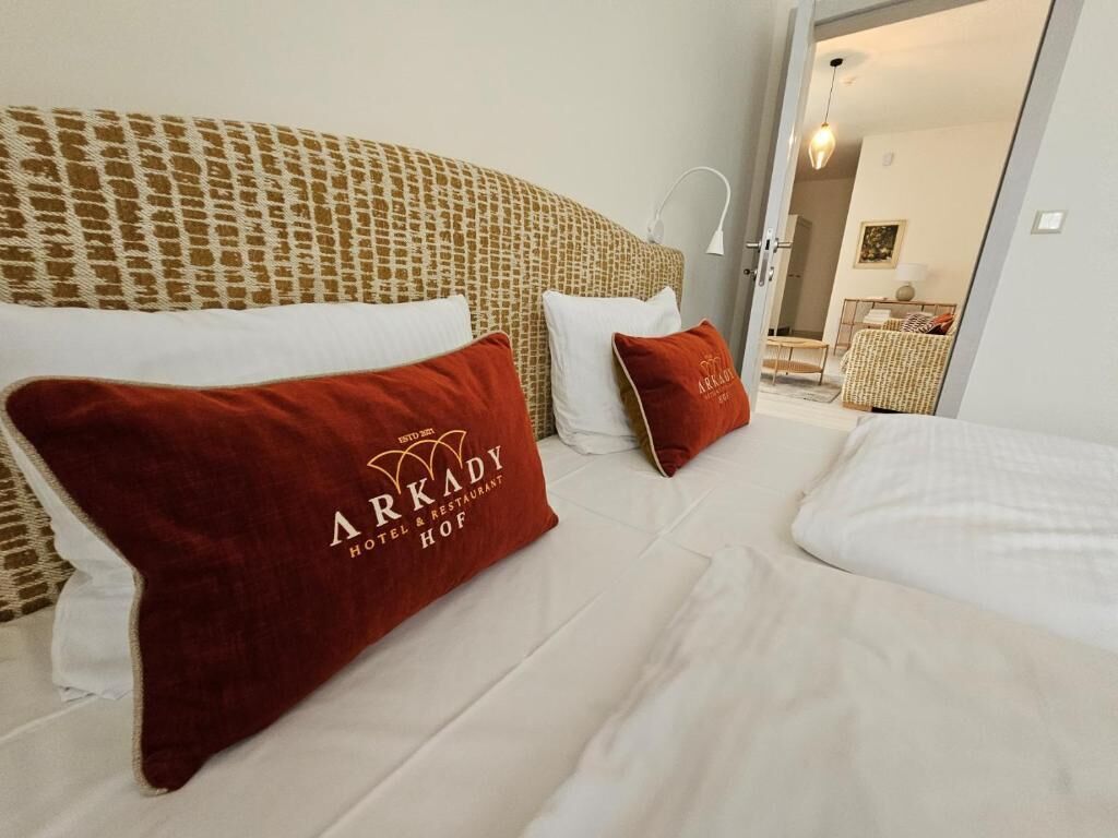 A hotel room with a bed, pillows, and a headboard.