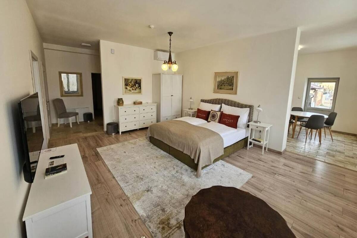 Un dormitorio con cama, mesitas de noche, escritorio, silla, armario y ventana.