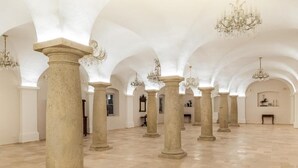 Un interior espacioso con techos altos, columnas arqueadas y candelabros.