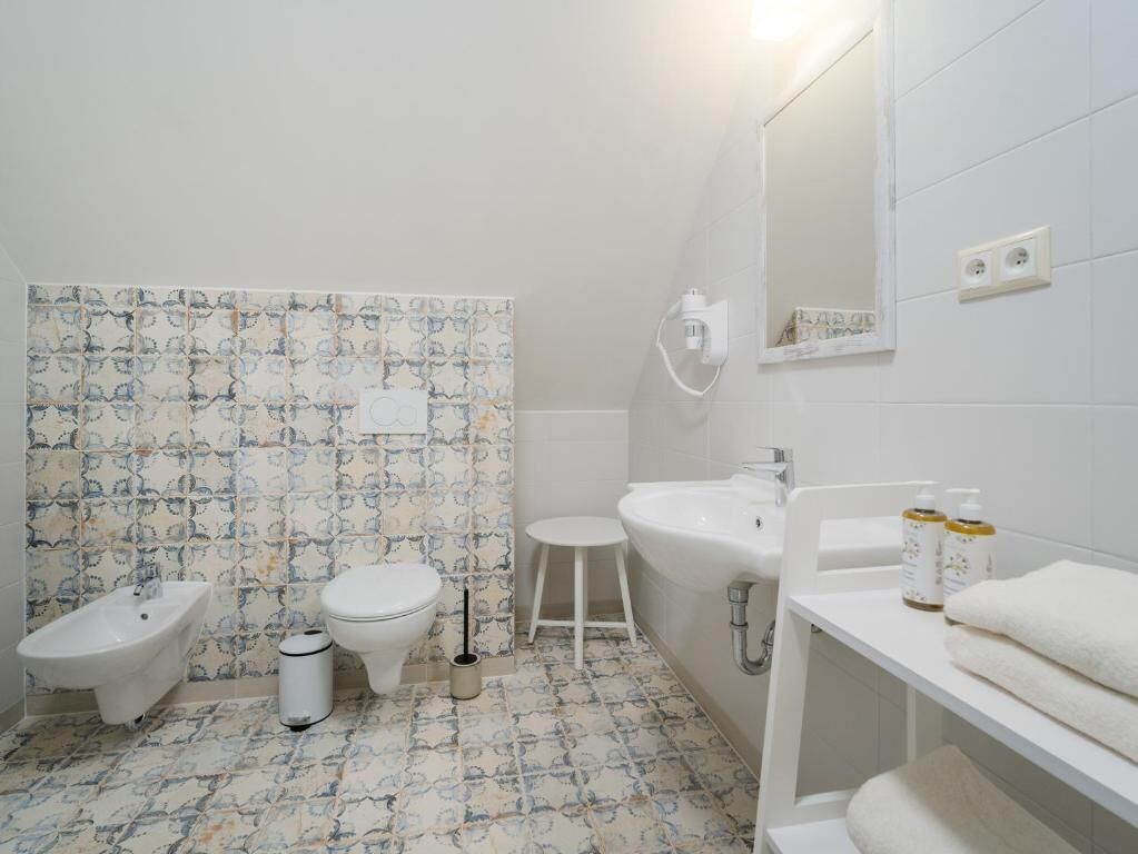 Un baño con bidé, inodoro, lavabo y espejo.
