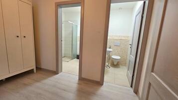 Pasillo que conduce a un baño con inodoro y lavamanos.