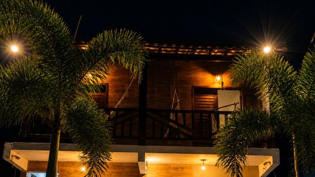 A two-story building with a wooden facade, a sign reading 'Pousada Vila Cactos,' and a staircase leading to the upper level. - Pousada Vila Cactos Jeri (Jijoca de Jericoacoara)